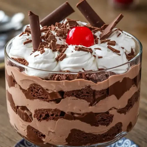 Delicious chocolate trifle layered with cake, chocolate mousse, and whipped cream.